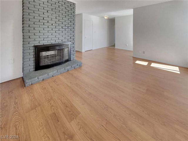 unfurnished living room with a fireplace and light hardwood / wood-style flooring