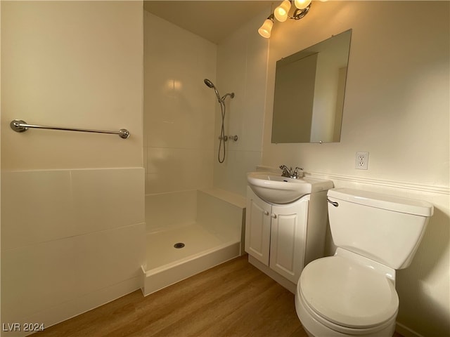 bathroom featuring walk in shower, vanity, wood-type flooring, and toilet