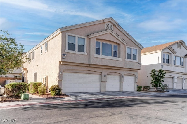 townhome / multi-family property featuring a garage and central AC unit