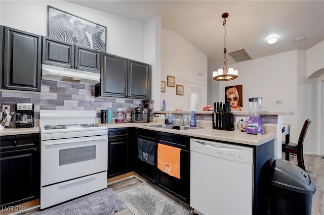 kitchen featuring white appliances, tasteful backsplash, kitchen peninsula, and hanging light fixtures