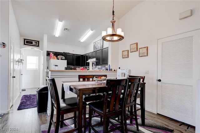 dining room featuring an inviting chandelier, lofted ceiling, and dark hardwood / wood-style floors