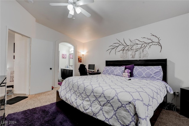 carpeted bedroom with ensuite bath and ceiling fan