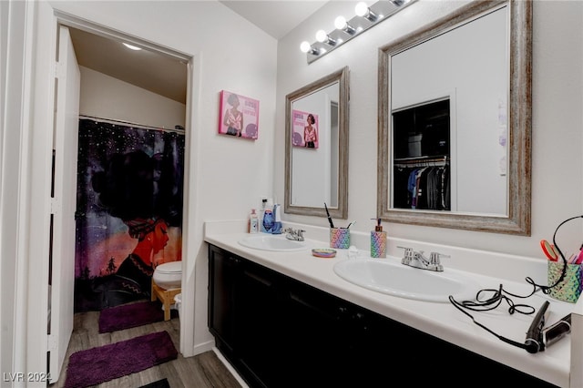 bathroom featuring vanity, lofted ceiling, hardwood / wood-style floors, and toilet