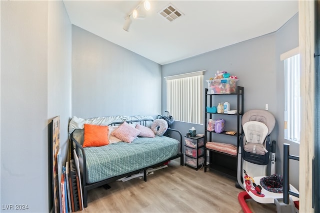 bedroom featuring light hardwood / wood-style floors and track lighting