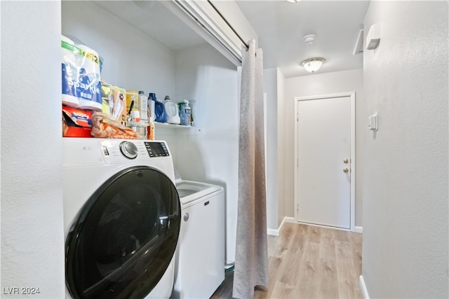 washroom featuring light wood-type flooring and washing machine and clothes dryer