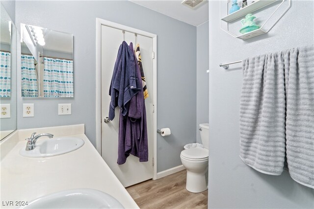 bathroom with toilet, hardwood / wood-style floors, and vanity