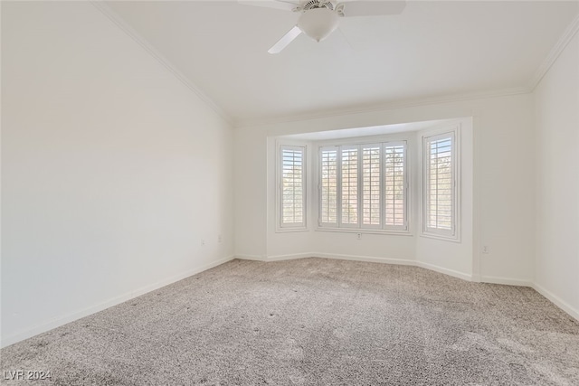 empty room with crown molding, vaulted ceiling, carpet, and ceiling fan