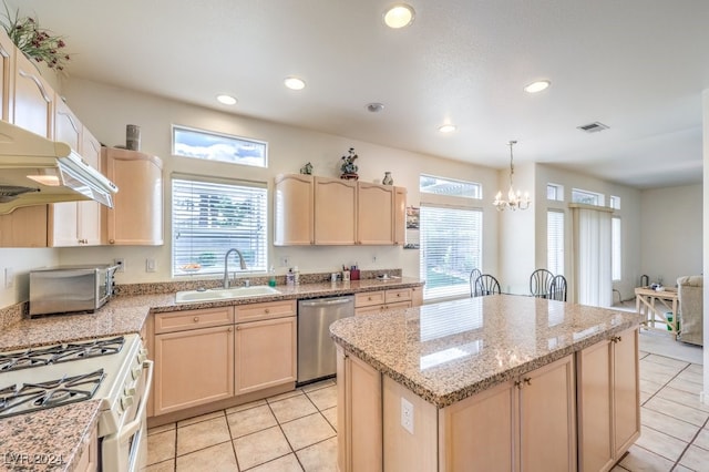 kitchen with a center island, stainless steel dishwasher, sink, and light brown cabinetry