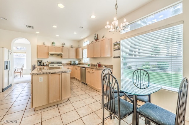 kitchen with light stone counters, light tile patterned floors, a kitchen island, light brown cabinetry, and stainless steel appliances