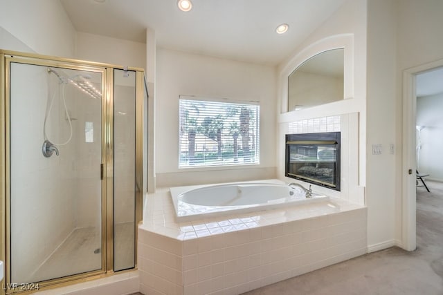 bathroom featuring shower with separate bathtub and a tile fireplace