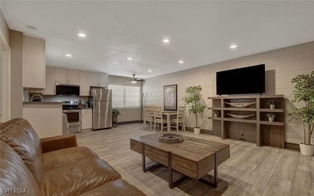 living room with ceiling fan and light wood-type flooring