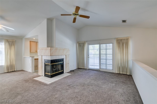 unfurnished living room featuring vaulted ceiling, light carpet, a tile fireplace, and ceiling fan