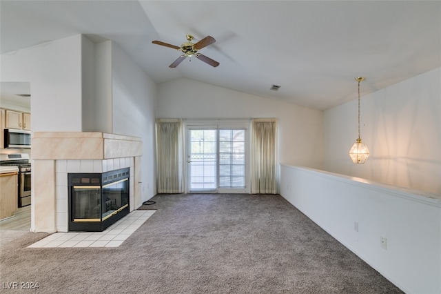 unfurnished living room featuring ceiling fan, lofted ceiling, a tile fireplace, and light colored carpet