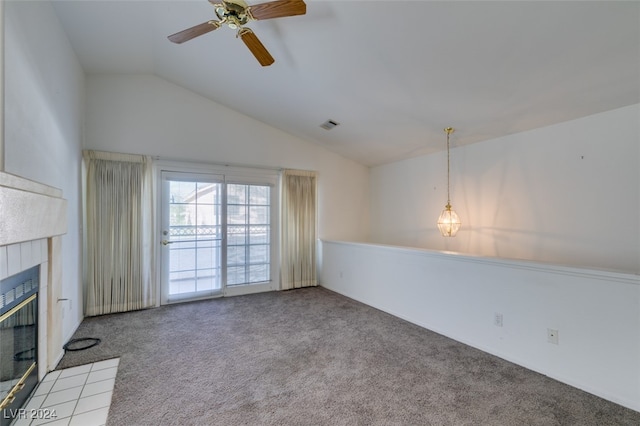 unfurnished living room with a tiled fireplace, carpet, vaulted ceiling, and ceiling fan