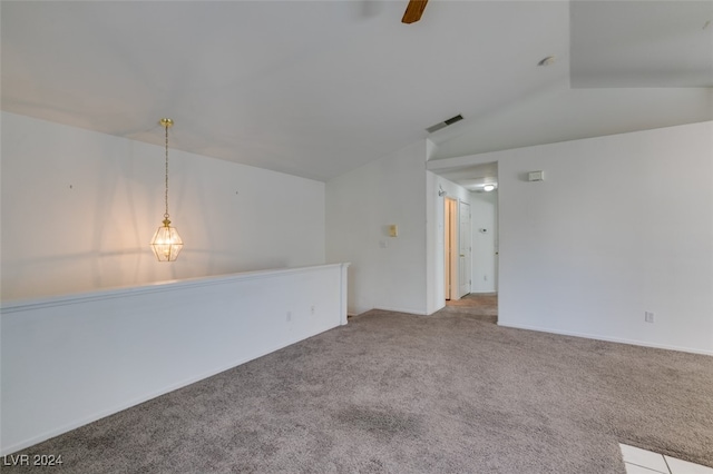 carpeted spare room featuring ceiling fan and vaulted ceiling