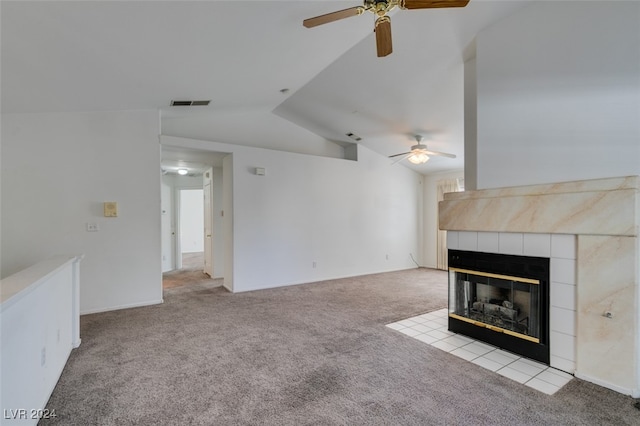 unfurnished living room featuring vaulted ceiling, light carpet, a tile fireplace, and ceiling fan