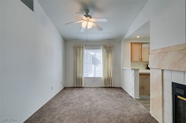 unfurnished living room with lofted ceiling, light colored carpet, a fireplace, and ceiling fan