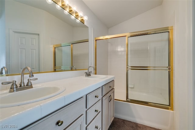 bathroom with vanity, lofted ceiling, and bath / shower combo with glass door