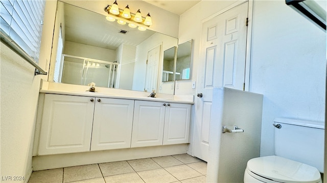 bathroom featuring vanity, toilet, tile patterned floors, and an enclosed shower