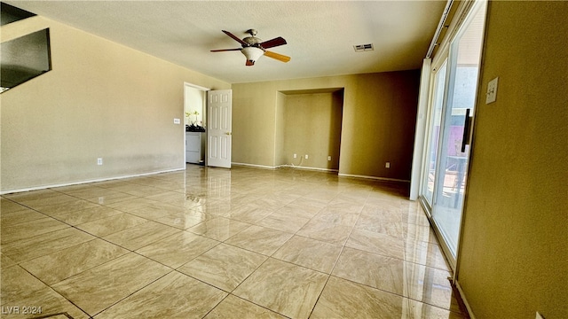 empty room featuring a textured ceiling and ceiling fan