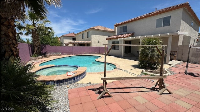 view of swimming pool featuring an in ground hot tub and a patio