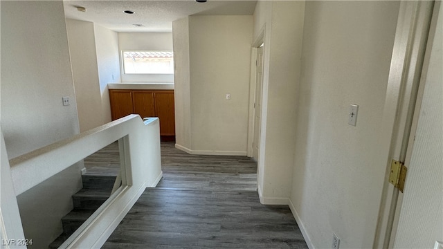 hall with dark hardwood / wood-style floors and a textured ceiling