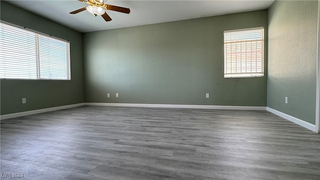 empty room featuring ceiling fan, wood-type flooring, and plenty of natural light