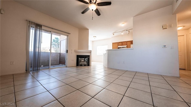 1050 E Cactus Ave Unit 2106, Las Vegas, NV 89183 - unfurnished living room with ceiling fan, light tile patterned floors, a fireplace, and rail lighting