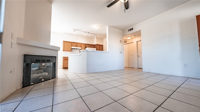 unfurnished living room with light tile patterned floors and ceiling fan