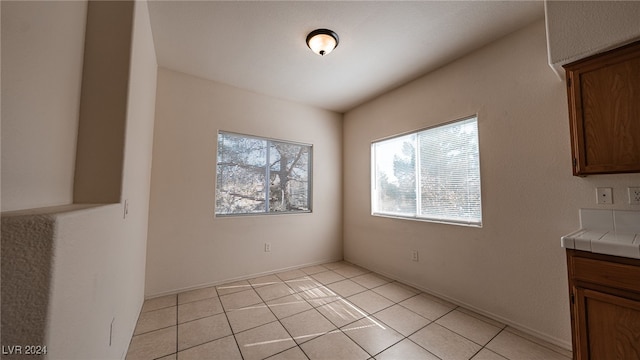 unfurnished dining area featuring light tile patterned flooring