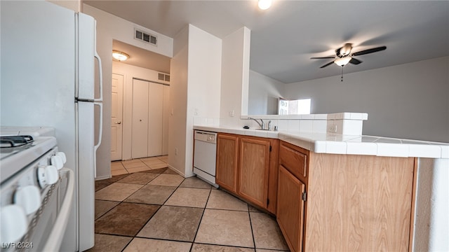 kitchen featuring white appliances, kitchen peninsula, ceiling fan, tile counters, and light tile patterned floors