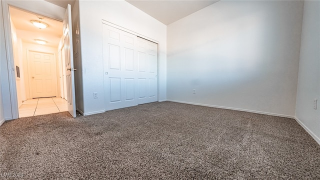 unfurnished bedroom featuring a closet and light carpet