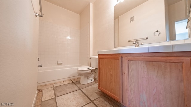 full bathroom featuring tiled shower / bath, vanity, and toilet