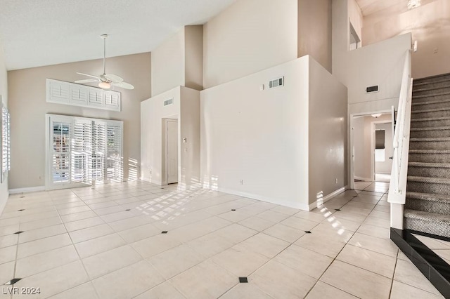 interior space with ceiling fan, light tile patterned flooring, and high vaulted ceiling