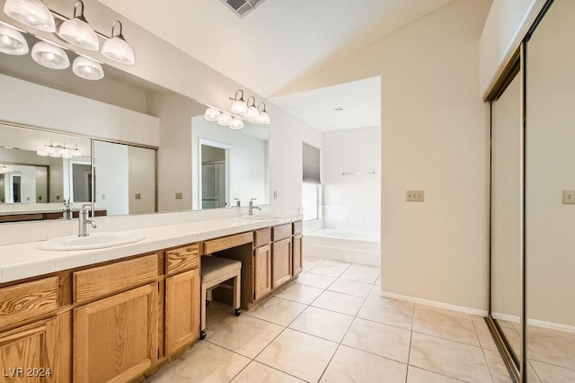 bathroom with tile patterned floors, vanity, lofted ceiling, and a bath