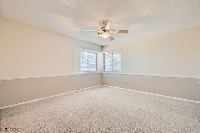 carpeted empty room with ceiling fan and a textured ceiling