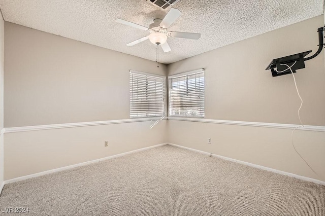 spare room featuring ceiling fan, carpet, and a textured ceiling