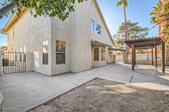 view of home's exterior with a pergola and a patio