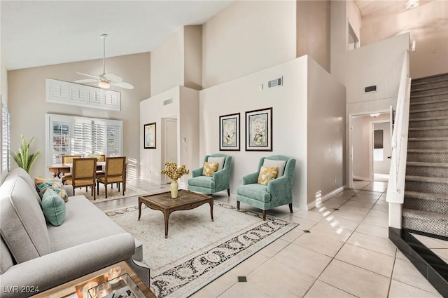 tiled living room with ceiling fan and high vaulted ceiling