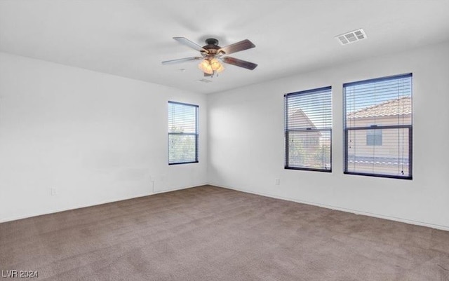 spare room featuring light carpet and ceiling fan