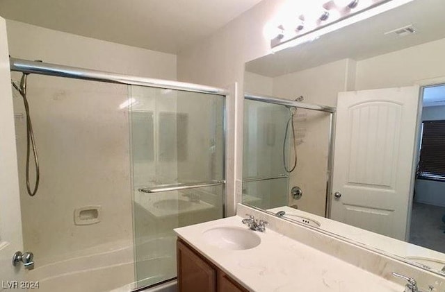 bathroom with vanity and enclosed tub / shower combo