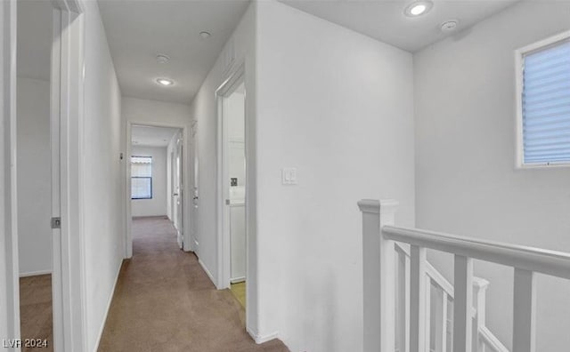 hallway featuring light colored carpet