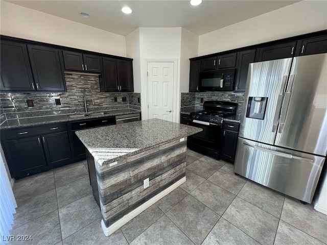 kitchen with decorative backsplash, sink, black appliances, light tile patterned floors, and dark stone countertops