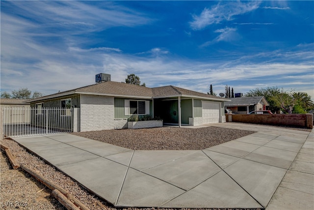 rear view of house with central AC unit and a garage