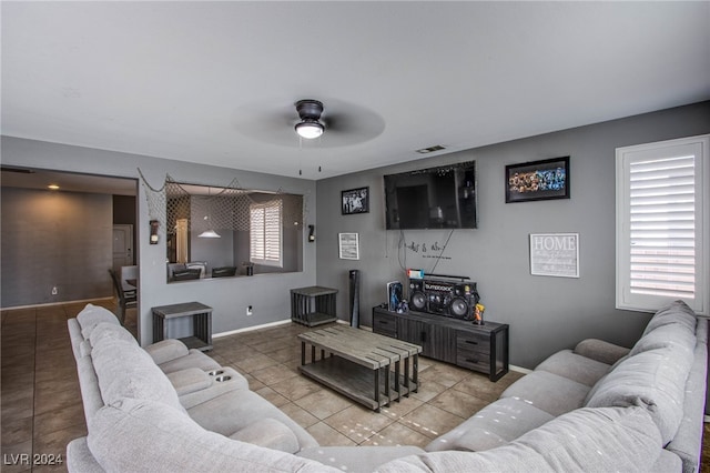 tiled living room featuring ceiling fan and plenty of natural light