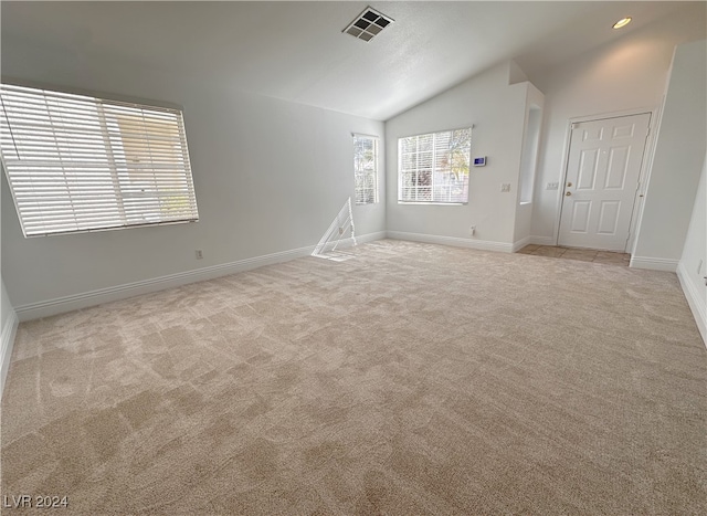 carpeted empty room featuring lofted ceiling