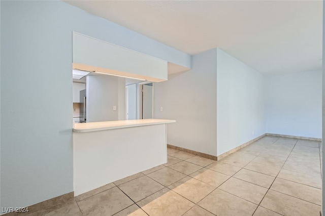 interior space featuring light tile patterned floors and kitchen peninsula