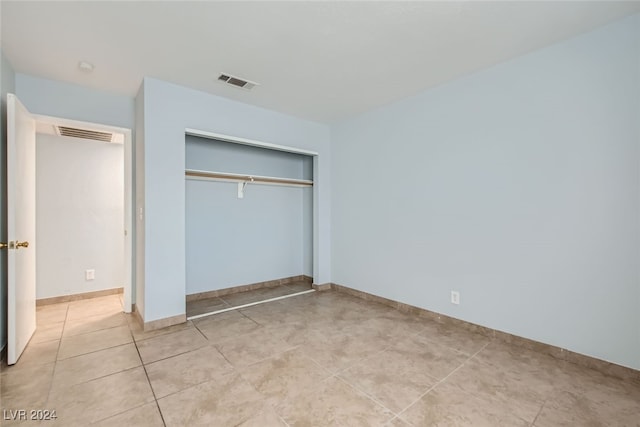 unfurnished bedroom featuring a closet and light tile patterned floors