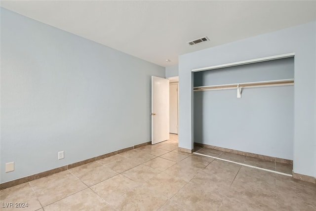 unfurnished bedroom with a closet and light tile patterned floors