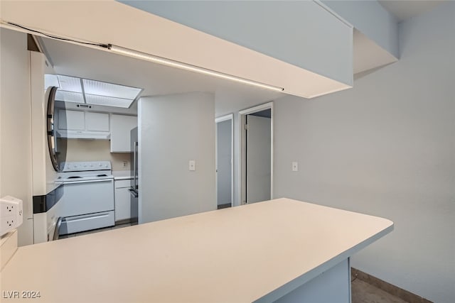 kitchen featuring white electric stove, white cabinetry, and kitchen peninsula